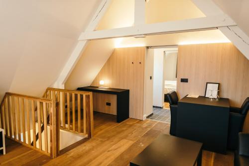 an attic room with a staircase and a desk at Guesthouse De Casteleer in Kasterlee