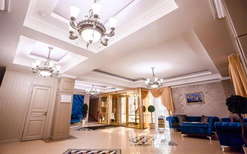 a lobby with blue chairs and a chandelier at Grand Sapphire Hotel in Almaty