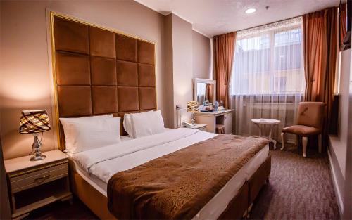a hotel room with a large bed and a window at Grand Sapphire Hotel in Almaty