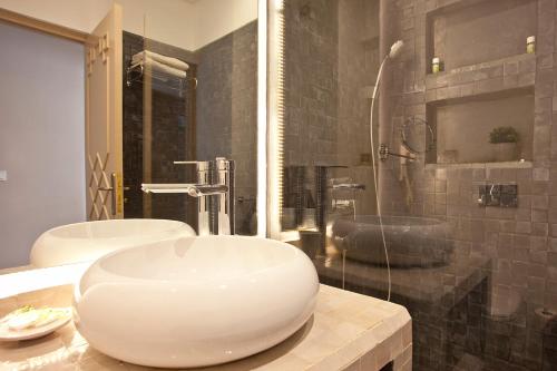 a bathroom with a white sink and a shower at Amani Hotel Suites & Spa in Marrakesh