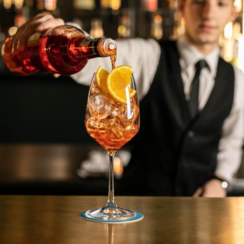 a drink being poured into a martini glass on a table at Bianca Maria Palace Hotel in Milan