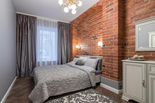 a bedroom with a brick wall and a bed at Dandelion apartment in the heart of Kaunas in Kaunas