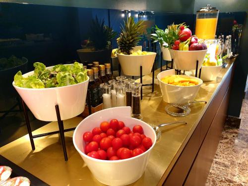 a buffet with bowls of fruit and vegetables on a counter at Bianca Maria Palace Hotel in Milan