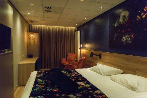 a hotel room with a bed and a chair at ´t Wapen van Marion in Oostvoorne