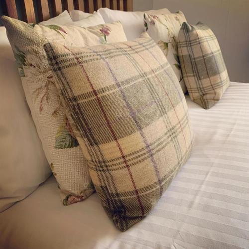 a plaid pillow sitting on top of a bed at Littletown Farm Guest House in Keswick