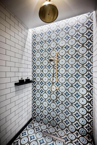 a bathroom with a tile wall with plates on the wall at The Merchant Baku in Baku