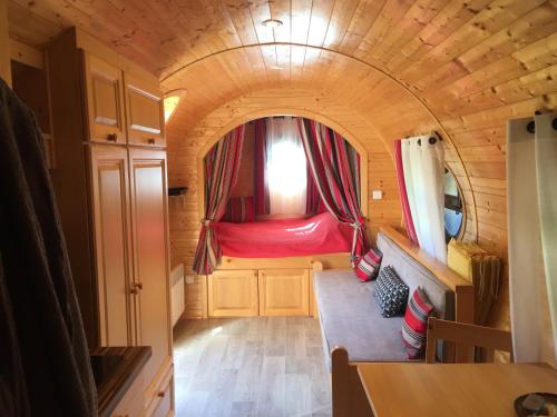 um pequeno quarto com uma cama vermelha numa pequena casa em Gîte Chais Catherine em Amboise