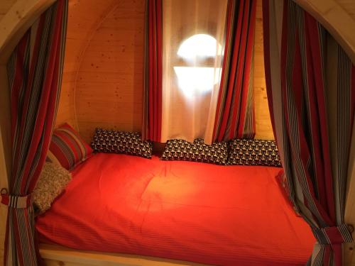a red bed in a room with a window at Gîte Chais Catherine in Amboise