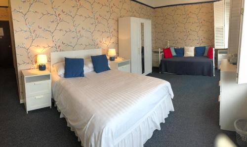 a bedroom with a large white bed and blue pillows at The Moorland Hotel in Wotter