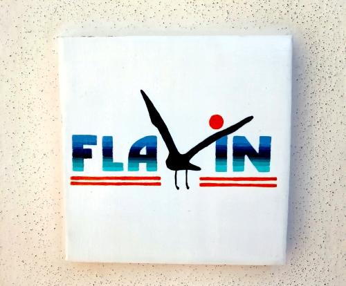 Un cartello su un muro che dice "flinin" di Casa Flavin Favignana a Favignana