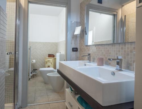 a bathroom with a white sink and a toilet at Realkasa Senzanome Flat in Bologna