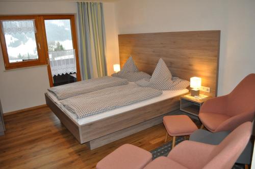 1 dormitorio con 1 cama grande y 2 sillas en Haus Zillach, en Bad Hindelang