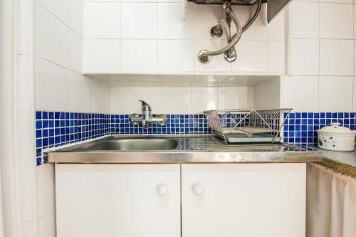 eine Küche mit einem Waschbecken und blauen und weißen Fliesen in der Unterkunft Apartamento Bairro Alto in Lissabon