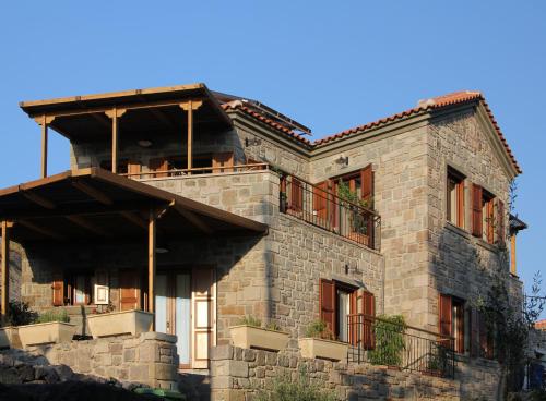 ein großes Steinhaus mit Balkon an der Seite in der Unterkunft Grand View Afrodite in Mythimna
