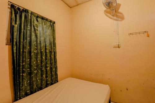 a small room with a bed and a fan at Omah Nggunung Cafe & Homestay in Yogyakarta