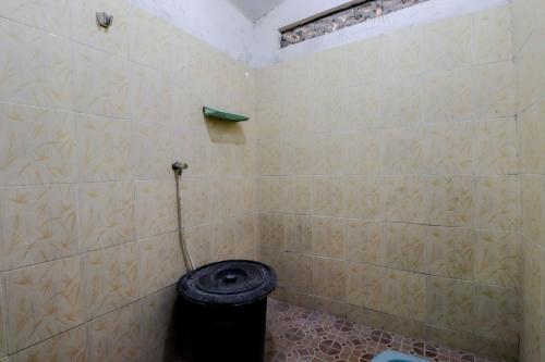 a bathroom with a toilet with a trash can at Omah Nggunung Cafe & Homestay in Yogyakarta