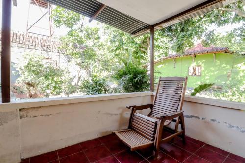 a rocking chair on the porch of a house at Omah Nggunung Cafe & Homestay in Yogyakarta