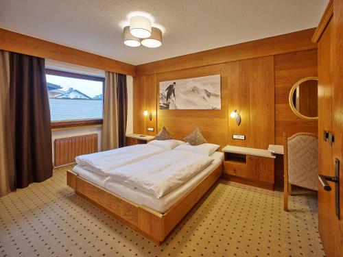 ein Schlafzimmer mit einem großen Bett und einem Fenster in der Unterkunft Apparthof Sunnwies in Oetz