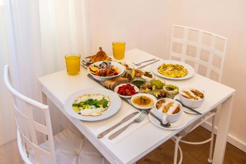a white table with plates of food and drinks at Mamilla View- Suites & Apt Hotel in Jerusalem