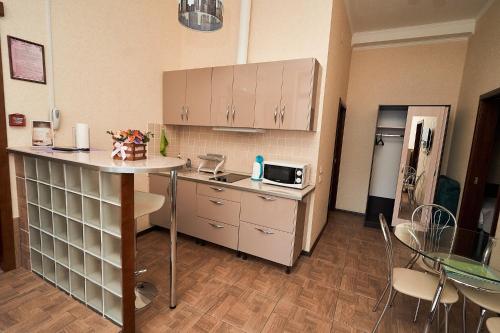 a kitchen with a counter and a table and a microwave at Sun City Hotel in Solnechnogorsk