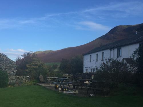 ein weißes Gebäude mit einem Picknicktisch im Gras in der Unterkunft Littletown Farm Guest House in Keswick