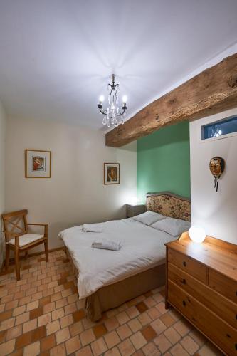 une chambre avec un grand lit et un lustre dans l'établissement Gîte La Terrasse - Manoir le Plessix Madeuc, à Corseul