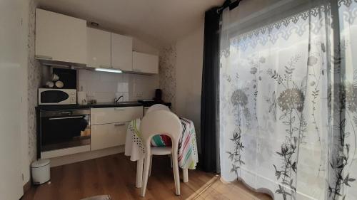 une cuisine avec une table et des chaises dans une cuisine dans l'établissement Zen et Nature, à Lagupie