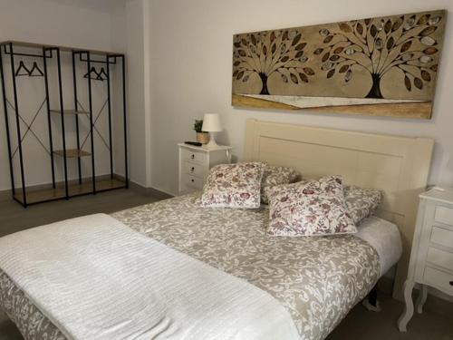 a bedroom with a bed and a painting on the wall at WISH SUITE NIEBLA DE SEVILLA in Seville