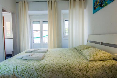 um quarto com uma cama com almofadas em Nice apartment in BAIRRO ALTO 6º em Lisboa