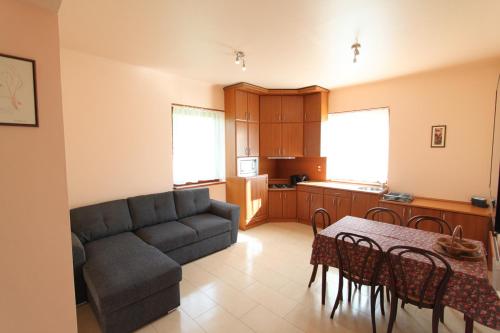 sala de estar con sofá, mesa y cocina en Velence Lake Apartman en Gárdony