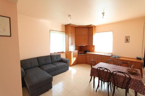 a living room with a couch and a table and a kitchen at Velence Lake Apartman in Gárdony