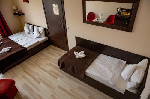 a hotel room with two beds and a mirror at Willa i domki Victoria in Wisła