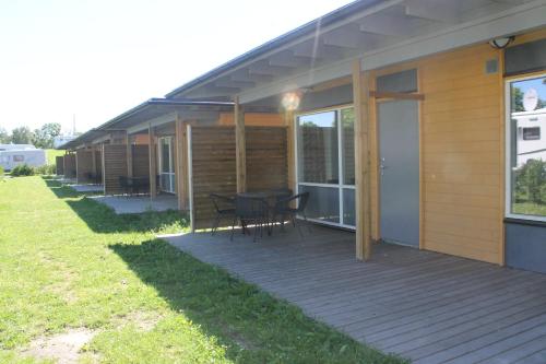ein Haus mit einer Terrasse mit einem Tisch und Stühlen in der Unterkunft Aktivitetsbyen Gamle Fredrikstad in Fredrikstad