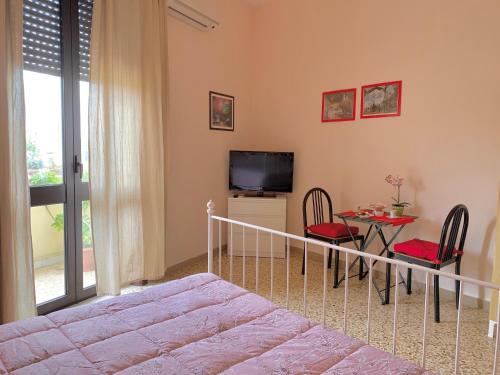 1 dormitorio con cama, mesa y TV en Luna Piena B&B, en Lecce