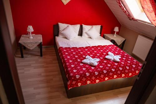 a bedroom with a bed with a red wall at Willa i domki Victoria in Wisła