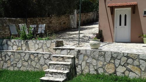a stone wall with a door and a vase on it at House of Garden in Dhráganon