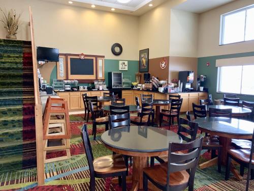 a dining room with tables and chairs in a restaurant at AmericInn by Wyndham Wausau in Weston