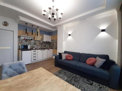 sala de estar con sofá azul y cocina en 2 BDR apartment near Gorky Park, Center en Járkov