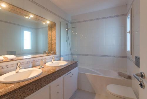 łazienka z 2 umywalkami i dużym lustrem w obiekcie Villa Casiopea w mieście Ibiza