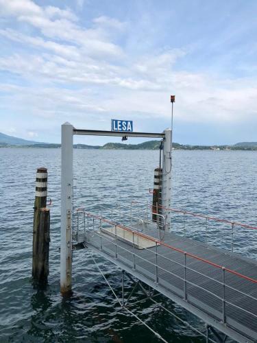 a dock in the water with a sign on it at Ballatoio Apartment by the Lake in Lesa