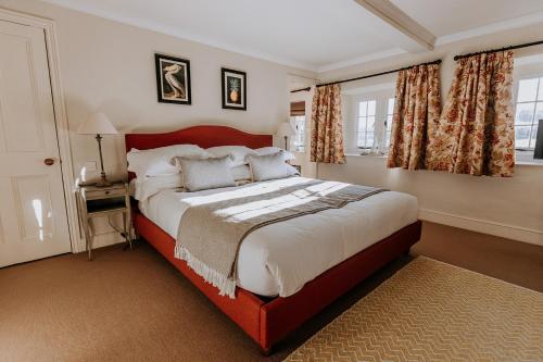 a bedroom with a large bed with a red headboard at Swinton Park in Masham
