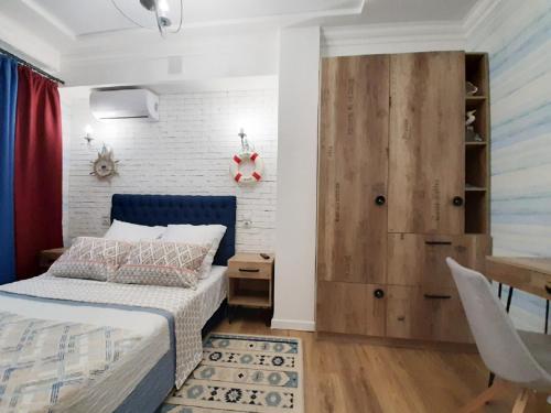 Un dormitorio con una cama azul y una pared de ladrillo en 2 BDR apartment near Gorky Park, Center en Járkov