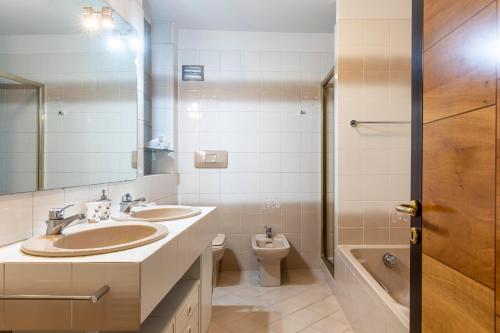 a bathroom with two sinks and a toilet at Apartment Goethe 1 in Bolzano