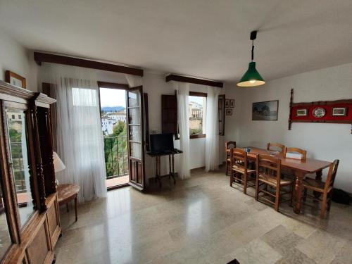 - un salon avec une table à manger et des chaises dans l'établissement Apartamento Balcones del Tajo, à Ronda