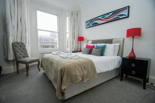 a bedroom with a bed and a chair and a window at Norton Apartment by Brighton Holiday Lets in Brighton & Hove