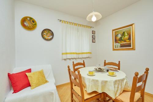 a dining room with a table and a couch at Apartments Zelic Tucepi in Tučepi