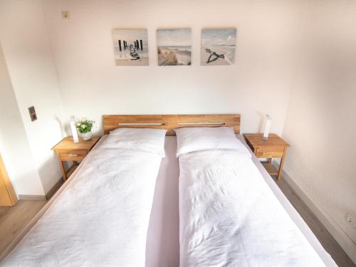 Bett in einem Zimmer mit drei Bildern an der Wand in der Unterkunft Appartement Ludwigskanal in Schwarzenbruck
