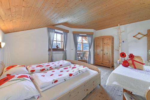 - une chambre avec deux lits et un plafond en bois dans l'établissement Ebenhof, à Collepietra
