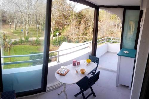 une pièce avec une table et des chaises sur un balcon dans l'établissement T2 Qaurtier Couchant, Vue parc, au calme, à 5 min de la plage, à La Grande Motte