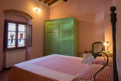 - une chambre avec un lit doté d'une armoire verte et d'une fenêtre dans l'établissement Agriturismo Casariccio - Casa Margherita, à Bucine